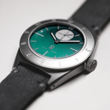 Closeup on the bottle green dial made of titanium. Swiss made. Automatic movement