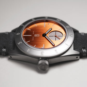 Closeup on the orange dial made of repurposed grade 5 titanium of the ecological watch made in Switzerland