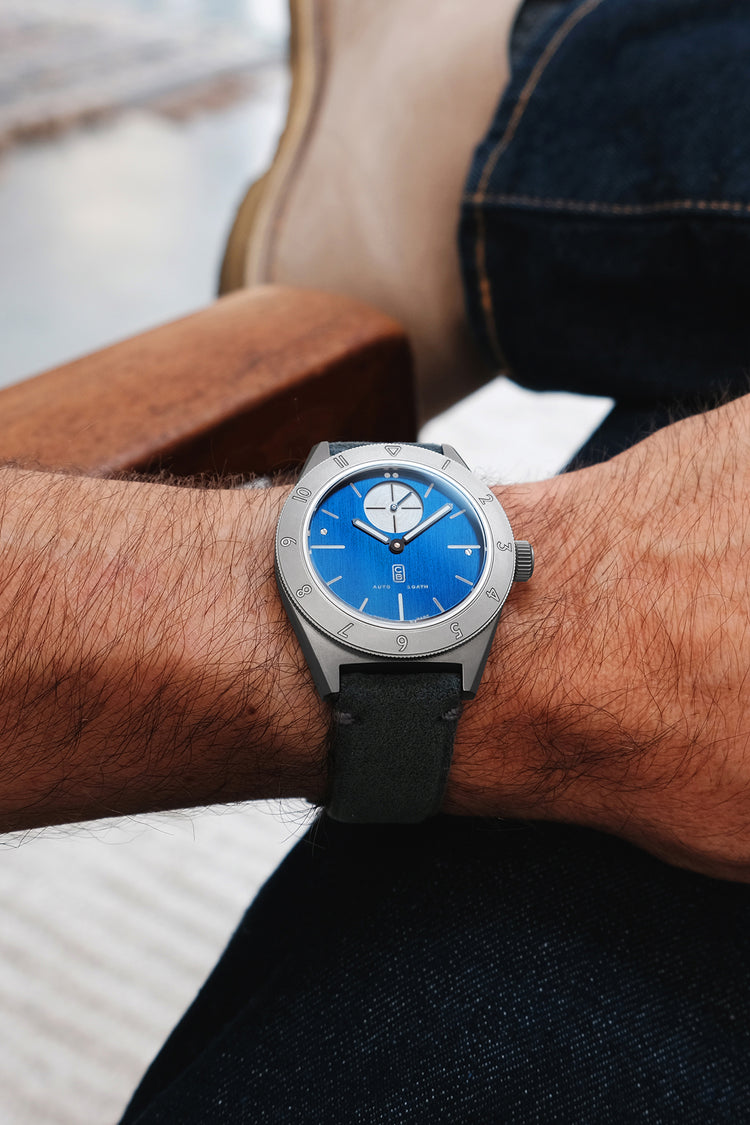 Grade 5 titanium tool watch for men worn on the owner's wrist. Blue dial, small second, dual time watch