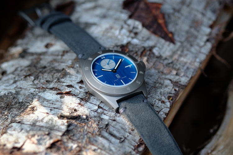 Cedric Bellon Swiss made watch made of repurposed grade 5 titanium on a piece of wood