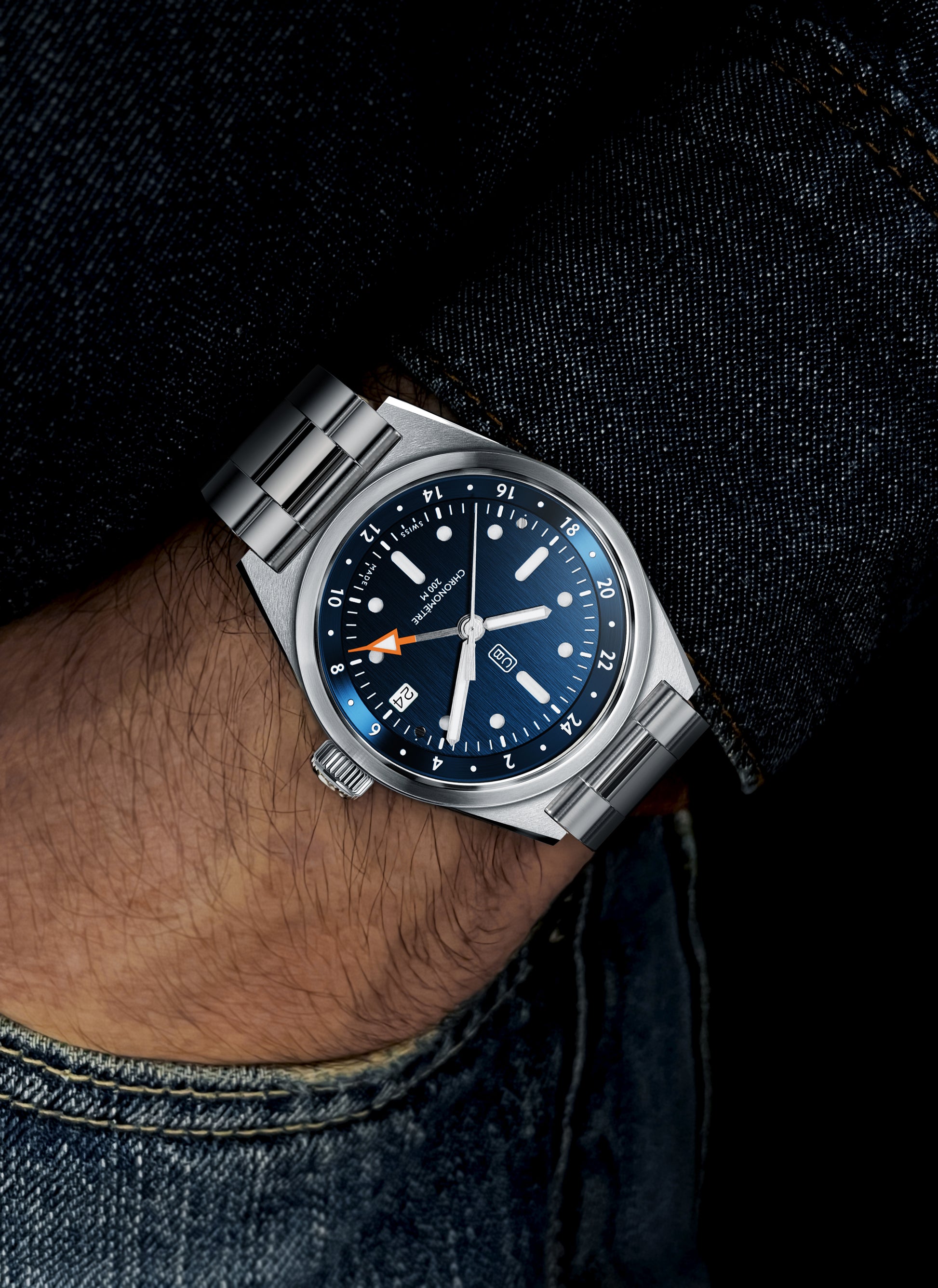 Full steel GMT watch, made of 100% recycled stainless steel, bue dial and Swiss made, worn by a men in denim clothes