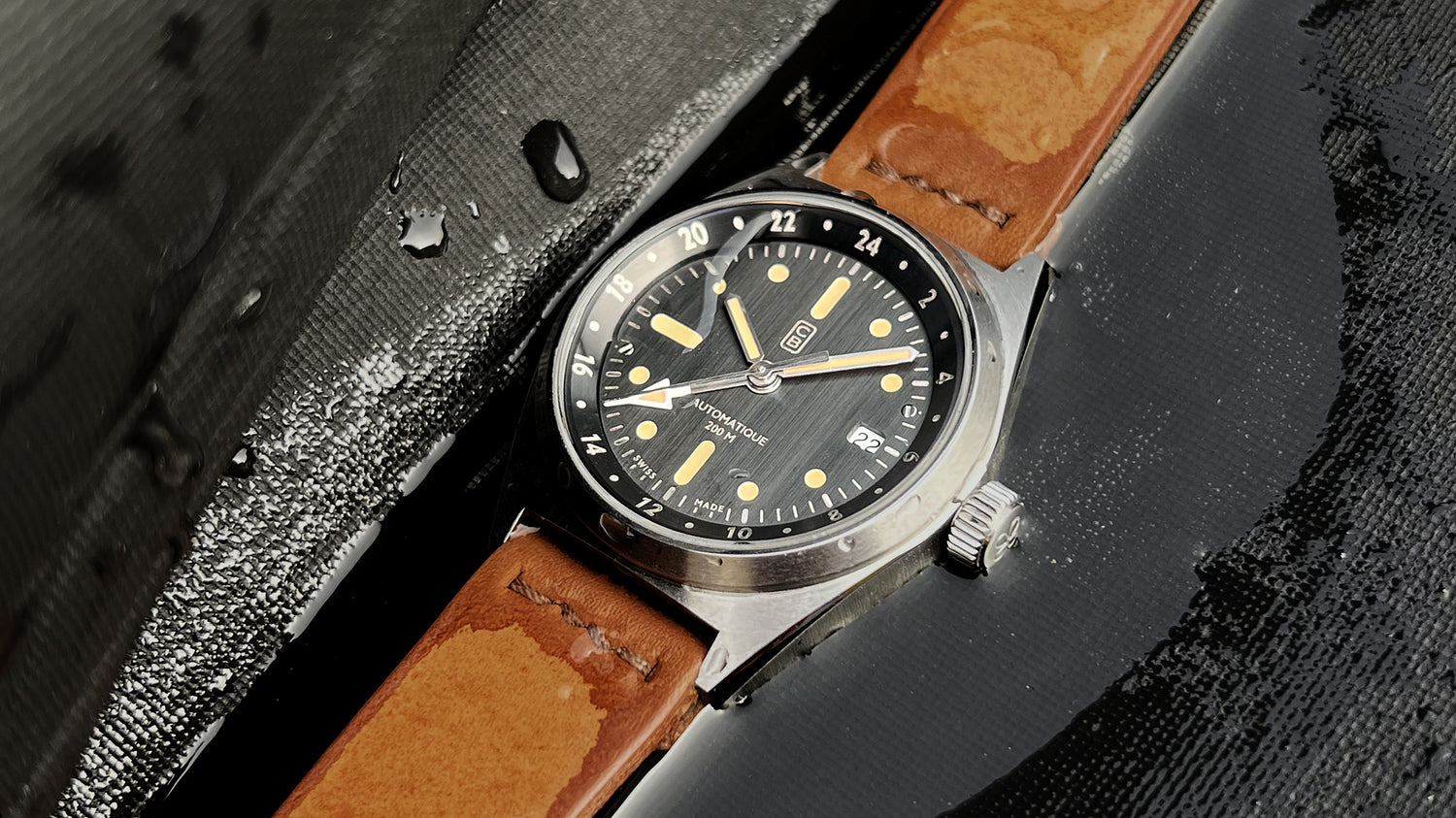 Wet sustainable watch made of recycled steel on diver's suit, handmade leather strap