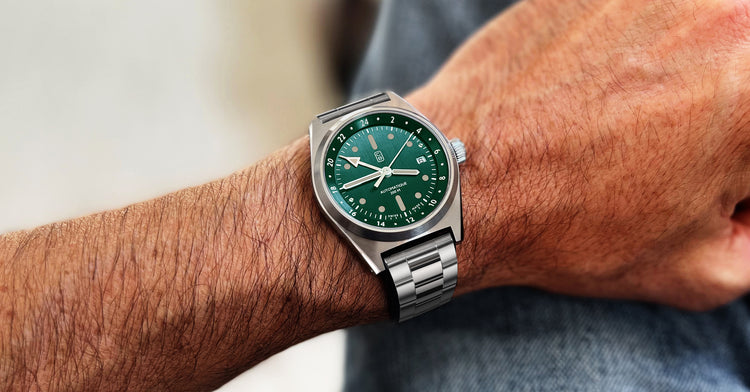 Full recycled stainless steel watch Cedric Bellon CB01-GMT with a bottle green dial worn on the wrist