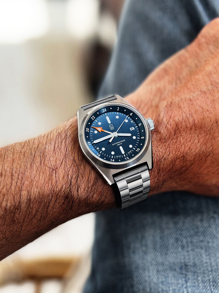 GMT men's watch worn the owner wrist. Blue dial and orange GMT hand tip