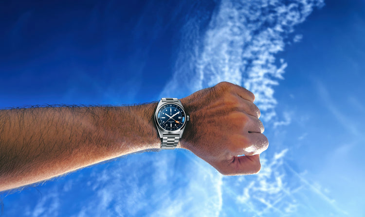 The beautiful blue of the dial of the CB01 GMT Cedric Bellon tool watch with a clear blue sky