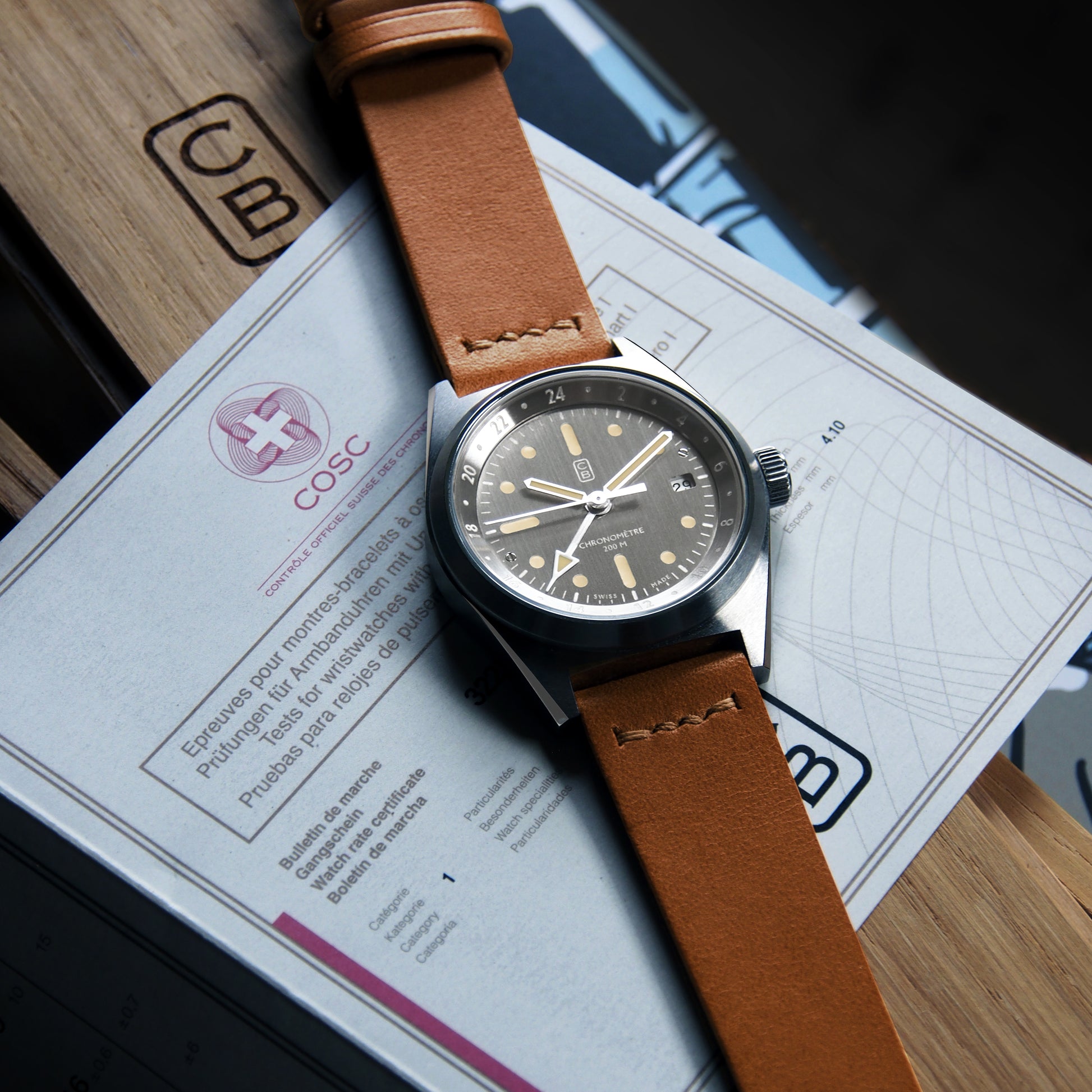 COSC Chronometer sustainable watch on its certificate. Raw dial taking sun reflects, GMT complication, the definition of a good Swiss made tool watch made of recycled steel.