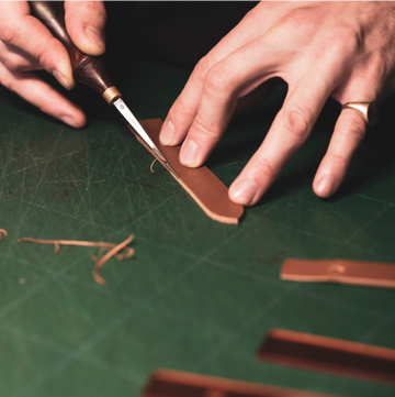 An artisan is making a watch strap by hand