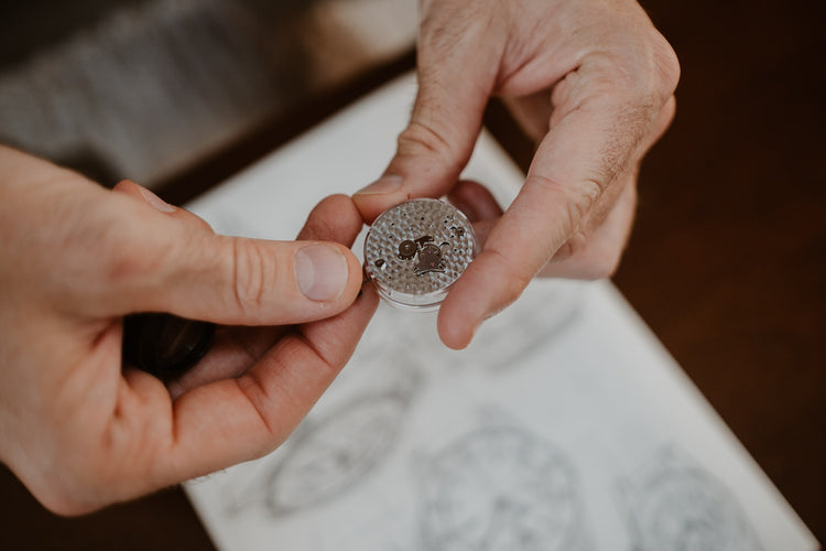 A Swiss made mechanical watch caliber hold in hands, natural and authentic environment